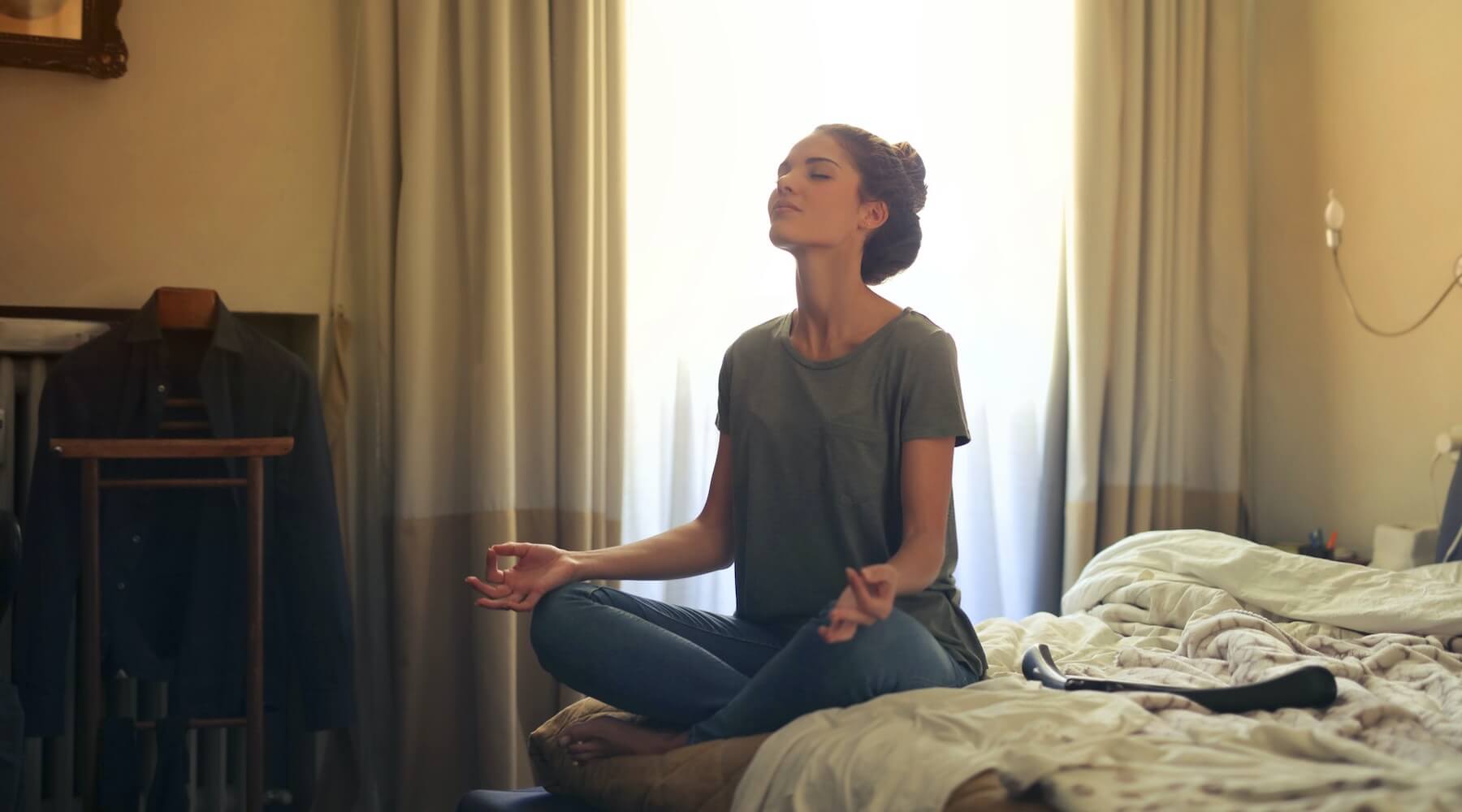 Woman meditating on bed
