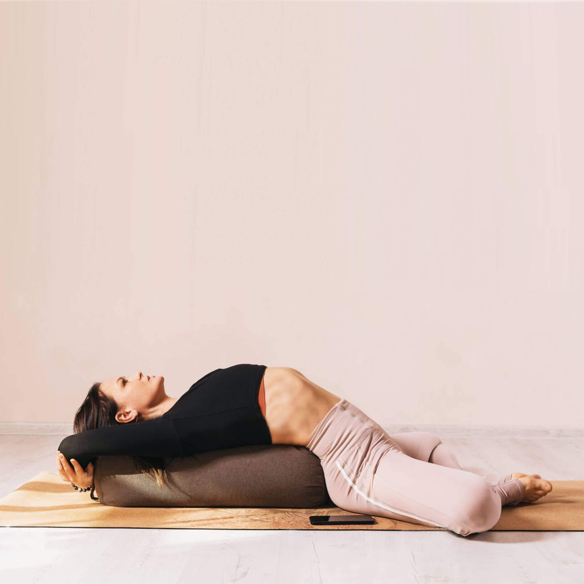 Woman lying down on yoga bolster
