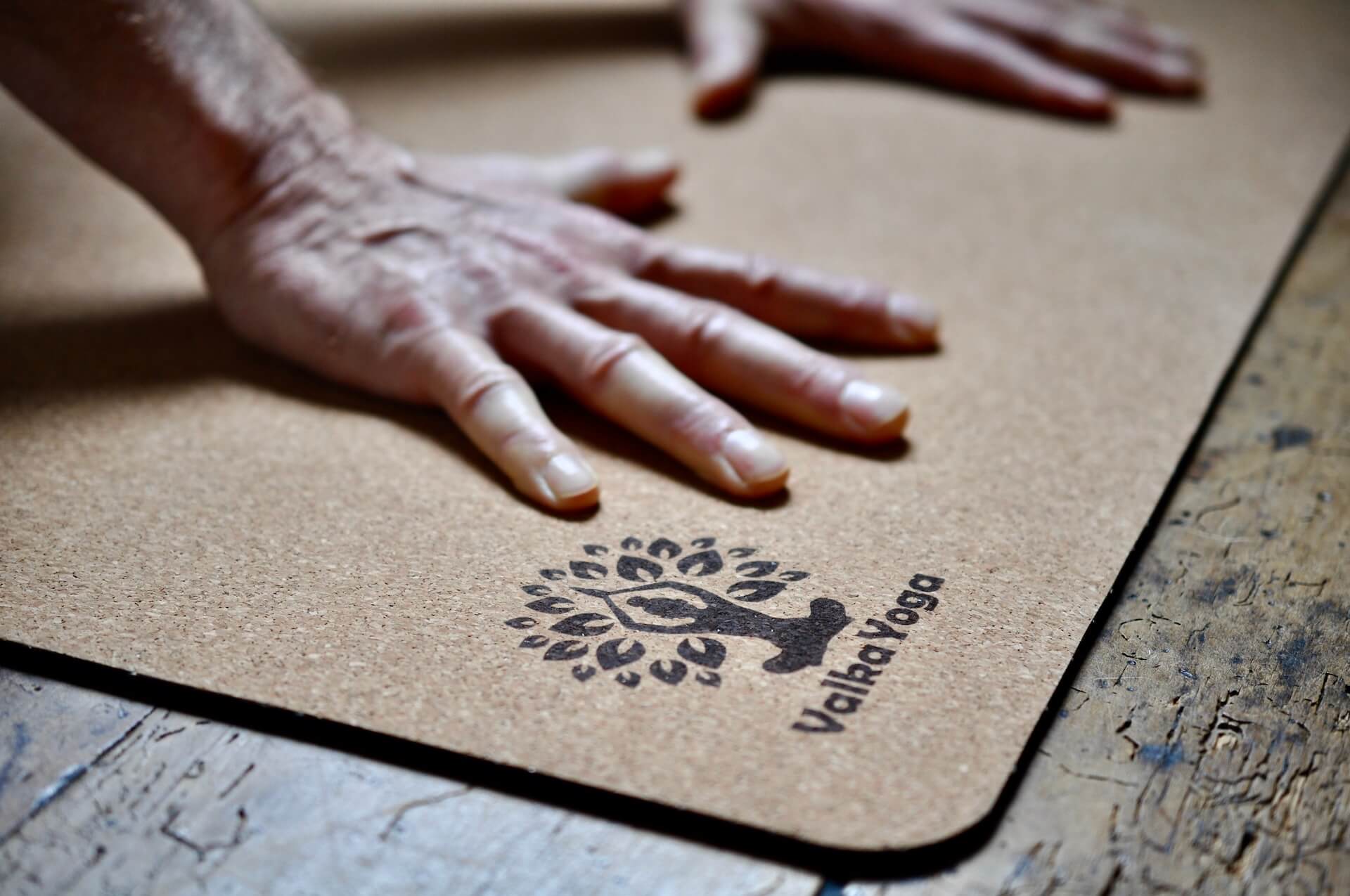 Man gripping cork yoga mat with Valka Yoga logo