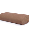 A brown / beige rectangular yoga bolster pillow with a small cork tag on the end, shown on a clean white background