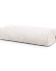 A rectangular bolster in an off white linen-like fabric, shown on a clean white background with a small cork tag on one end