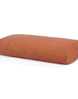 A rectangular lumbar bolster in a warm pink or orange colour, made of textured fabric, shown on a clean white background