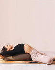 Woman lying down on yoga bolster